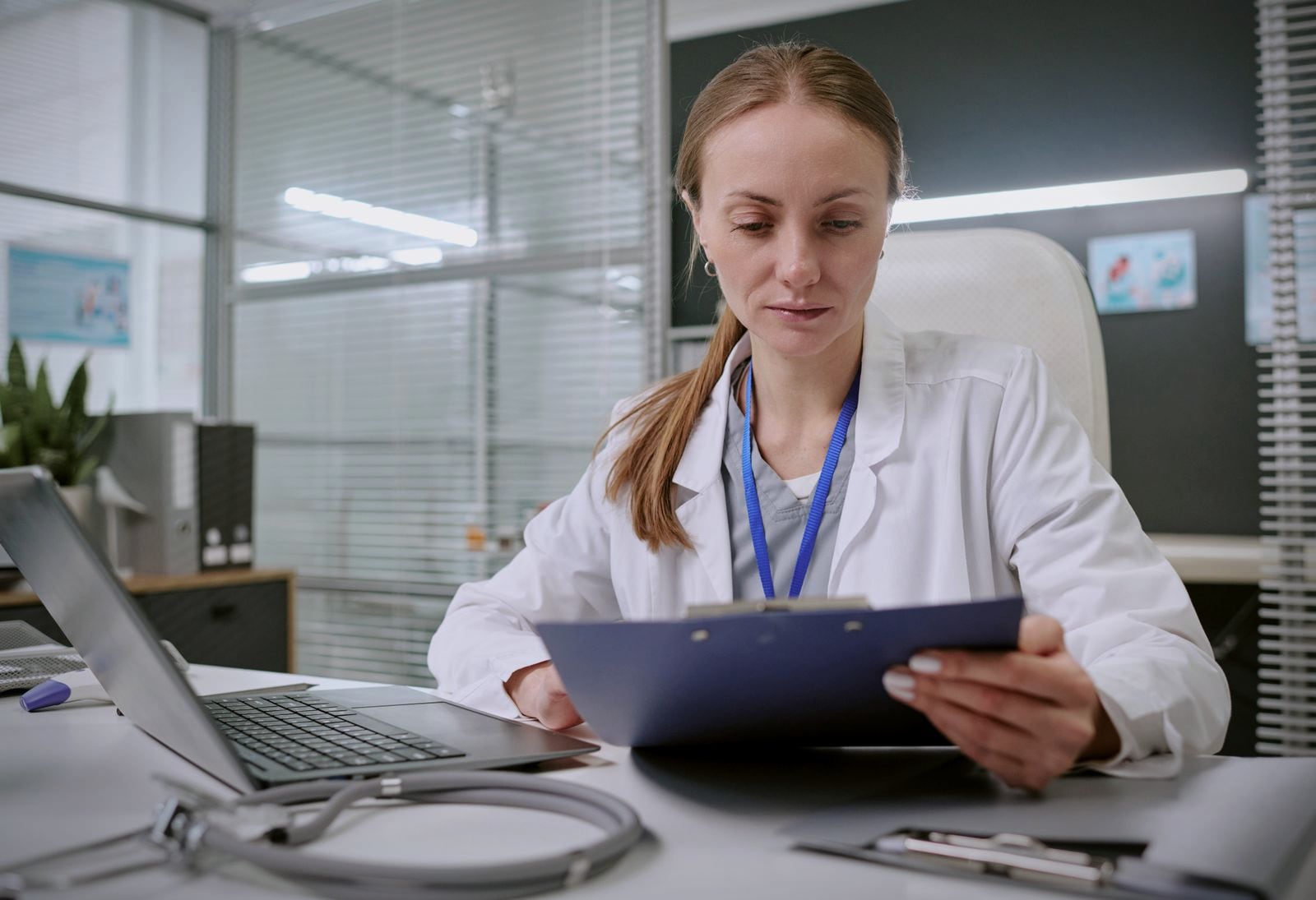 A doctor reviewing patient records at a clinic desk